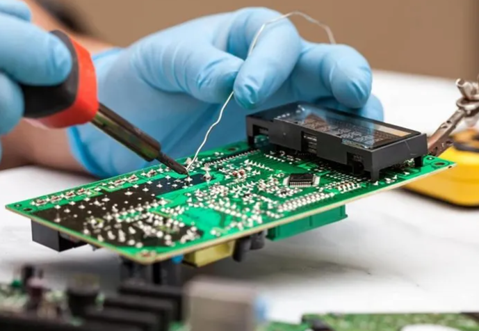 “在 PCB 上手工焊接径向引线元件。”